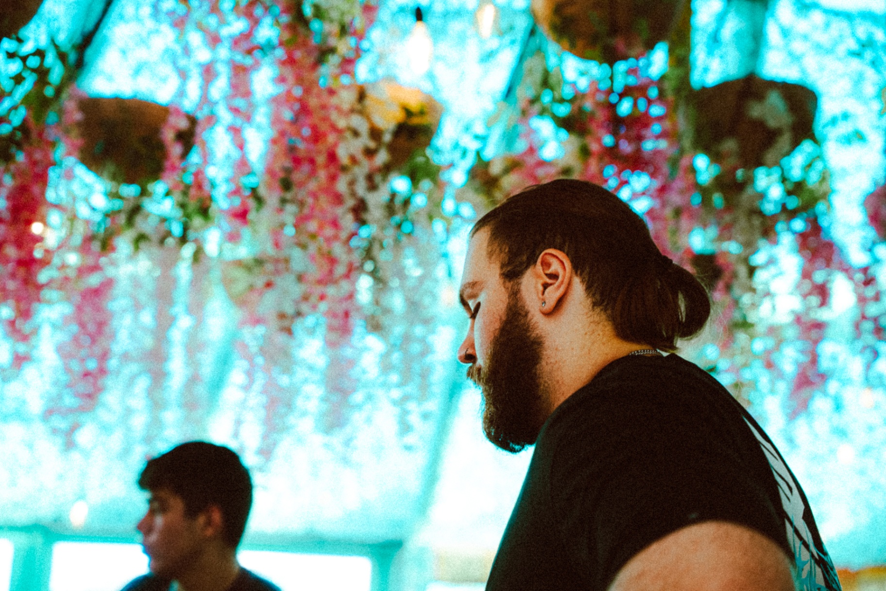 Hugo pulling cards beneath the wisteria-lit venue ceiling