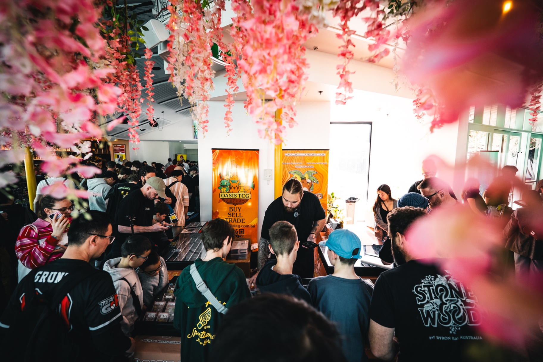 Packed room of collectors under wisteria at an Oasis TCG vending show